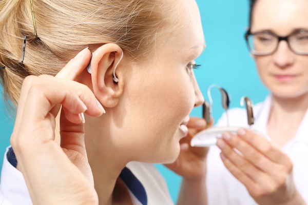 Young woman being fitted with a hearing aid 