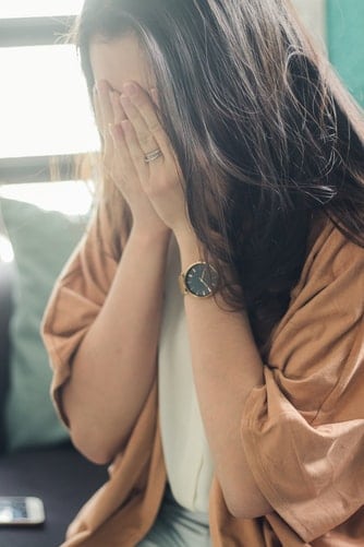 Woman covering her face.