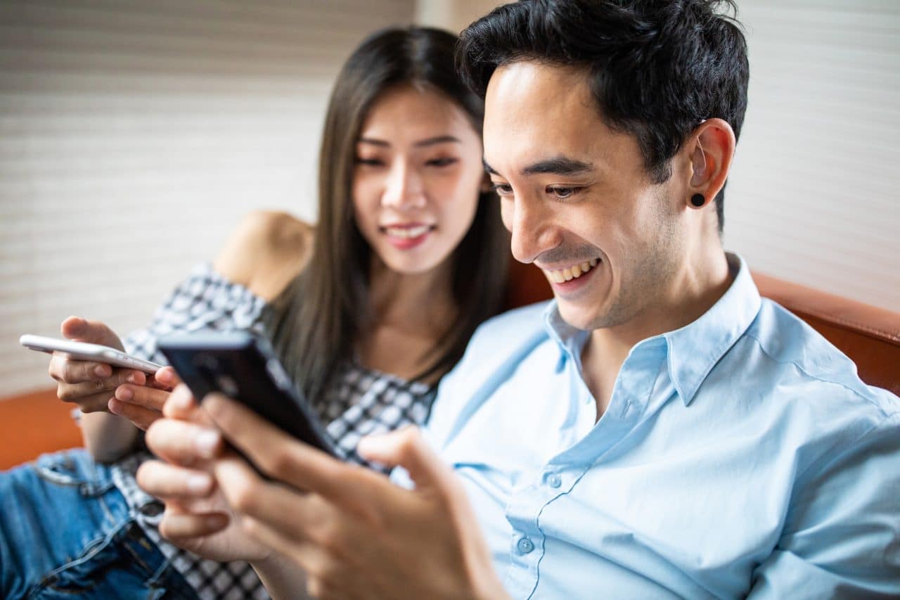 Couple relaxing, man wearing hearing aid.