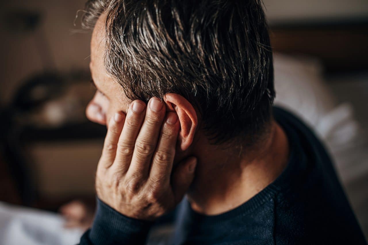 Man rubbing his ear.