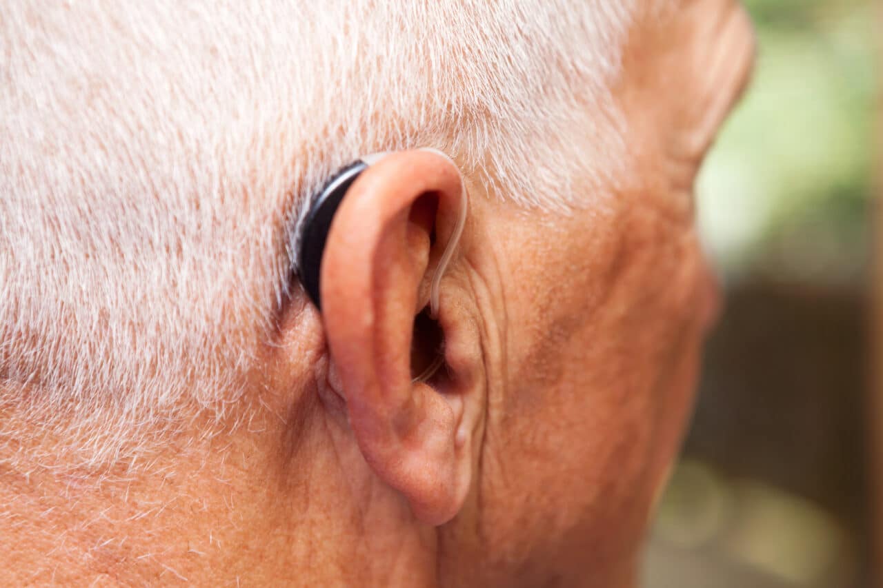 Close-up of an older man wearing a hearing aid.