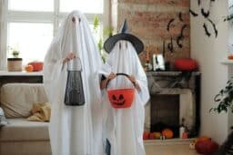 A parent and child dressed as ghosts for Halloween.