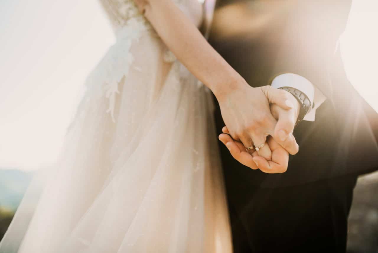 A close-up of the bride and groom's hands