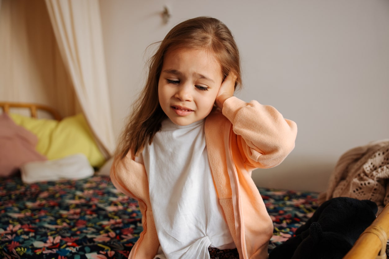 Young girl holding ear with ear infection