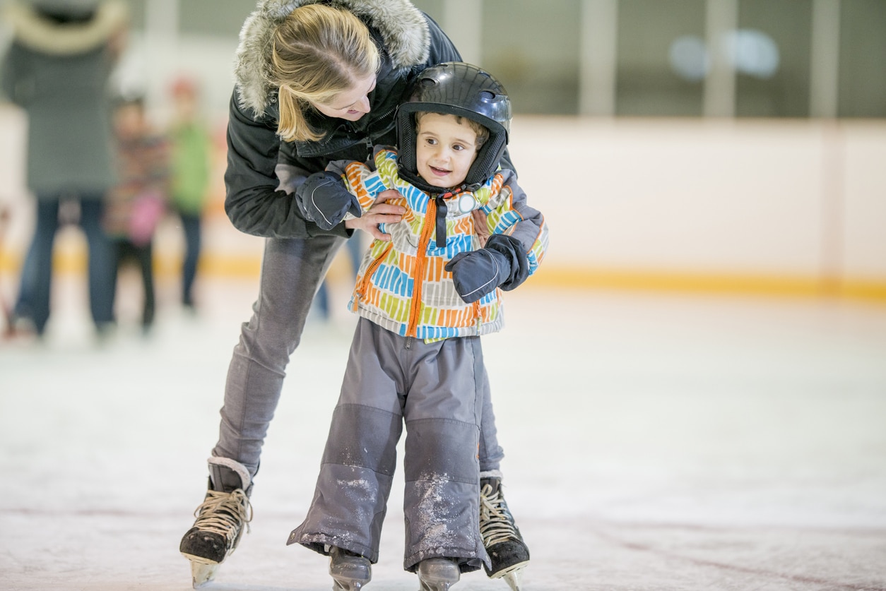 Mom teaching her young boy how to skate.