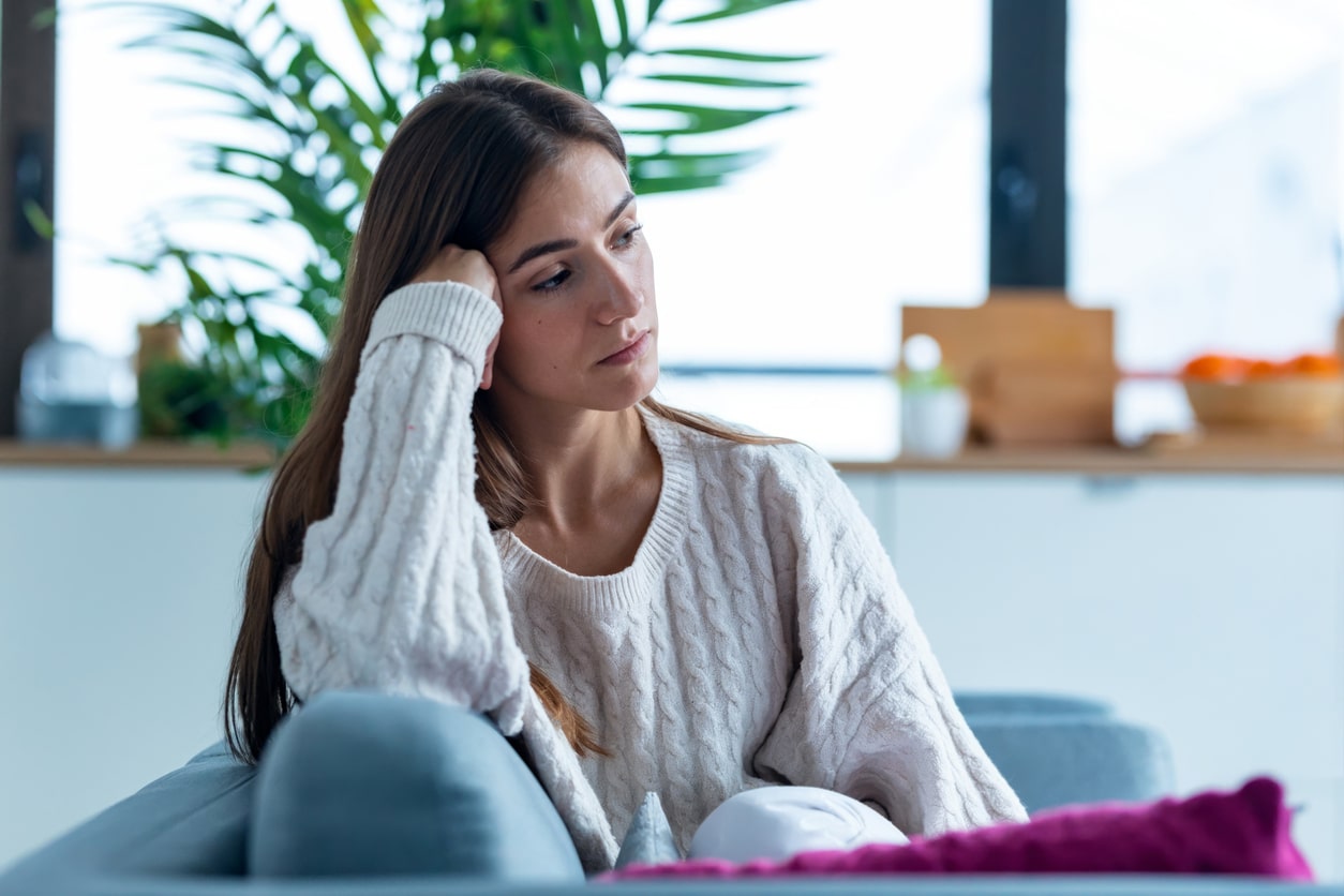 Sad woman sitting on the couch.